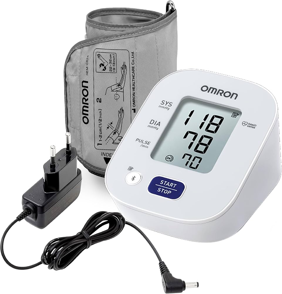 Omron blood pressure monitor with cuff and power adapter on a white background